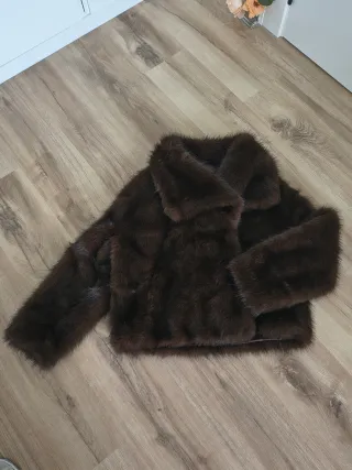 Chaquetón de pelo sintético en tono marrón.