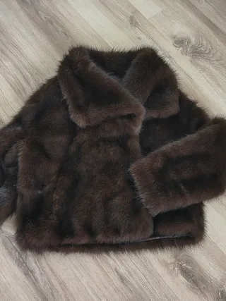 Chaquetón de pelo sintético en tono marrón.