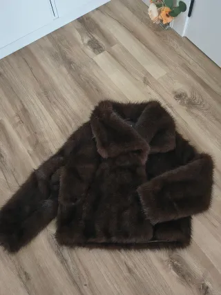 Chaquetón de pelo sintético en tono marrón.