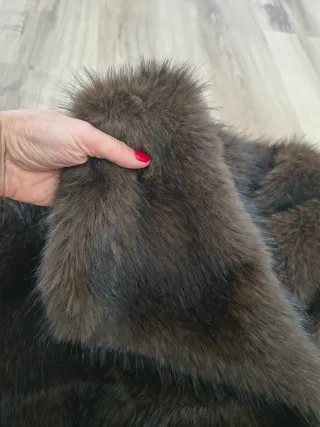 Chaquetón de pelo sintético en tono marrón.
