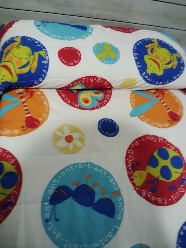 Colcha infantil colorida con dibujos de insectos