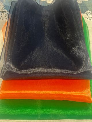 Fulares de tela azul, verde y naranja sin usar.