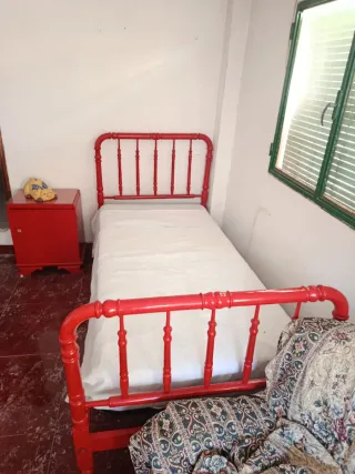 Cama antigua de metal roja