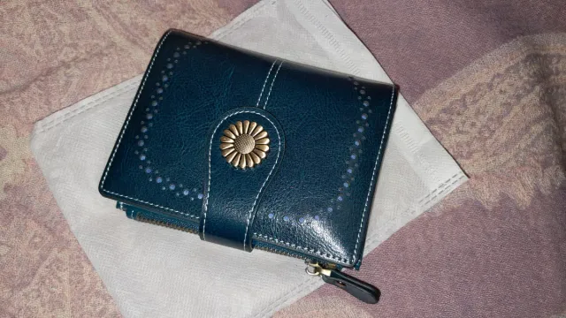 Cartera azul verdoso con detalle floral dorado