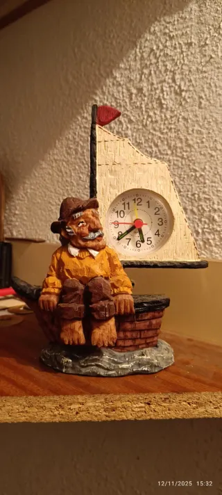 Figura de pescador en barco con reloj