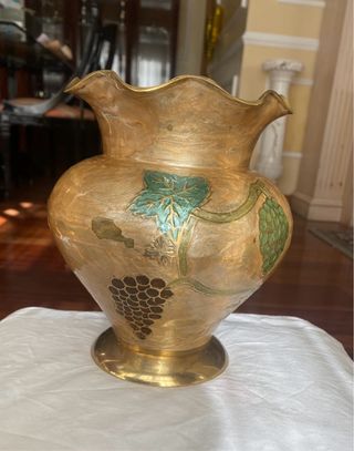 Jarrón de metal dorado con uvas