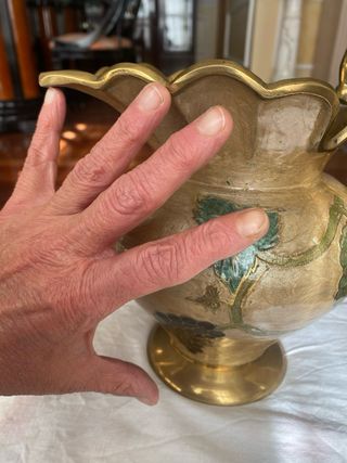 Jarrón de metal dorado con uvas