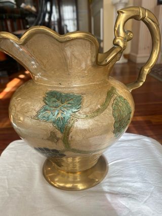 Jarrón de metal dorado con uvas