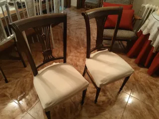 Dos sillas de madera con tapizado rosa