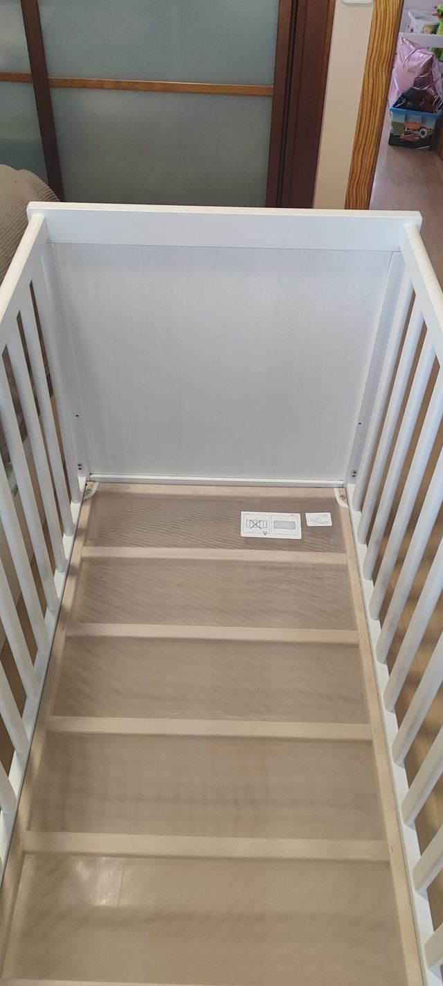 Cuna colecho blanca IKEA con colchón y barandilla.