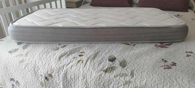 Cuna colecho blanca IKEA con colchón y barandilla.