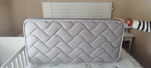 Cuna colecho blanca IKEA con colchón y barandilla.