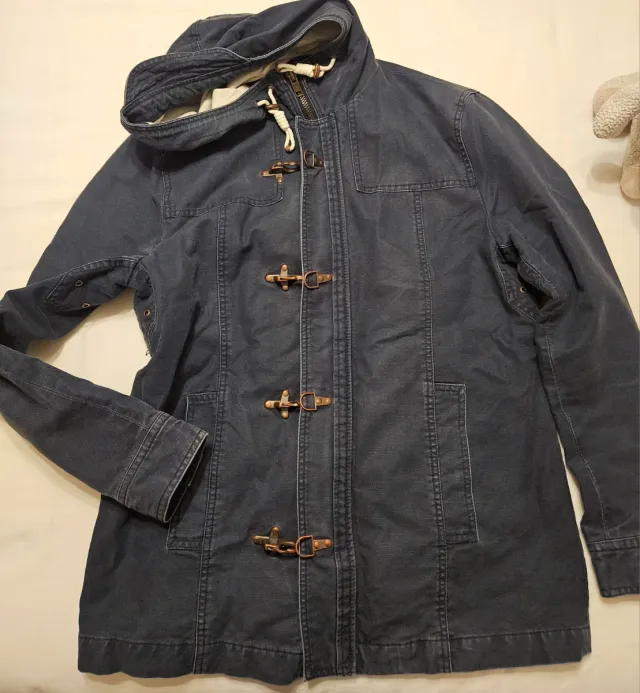 Trenca azul con capucha y cierres de metal