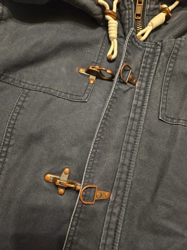 Trenca azul con capucha y cierres de metal