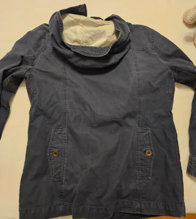 Trenca azul con capucha y cierres de metal