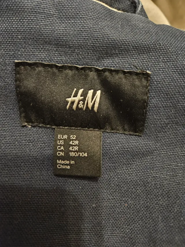 Trenca azul con capucha y cierres de metal