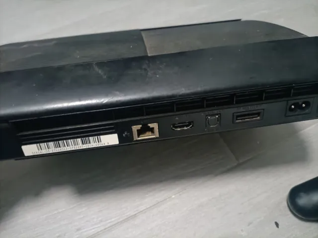 PlayStation 3 con mando y juego.