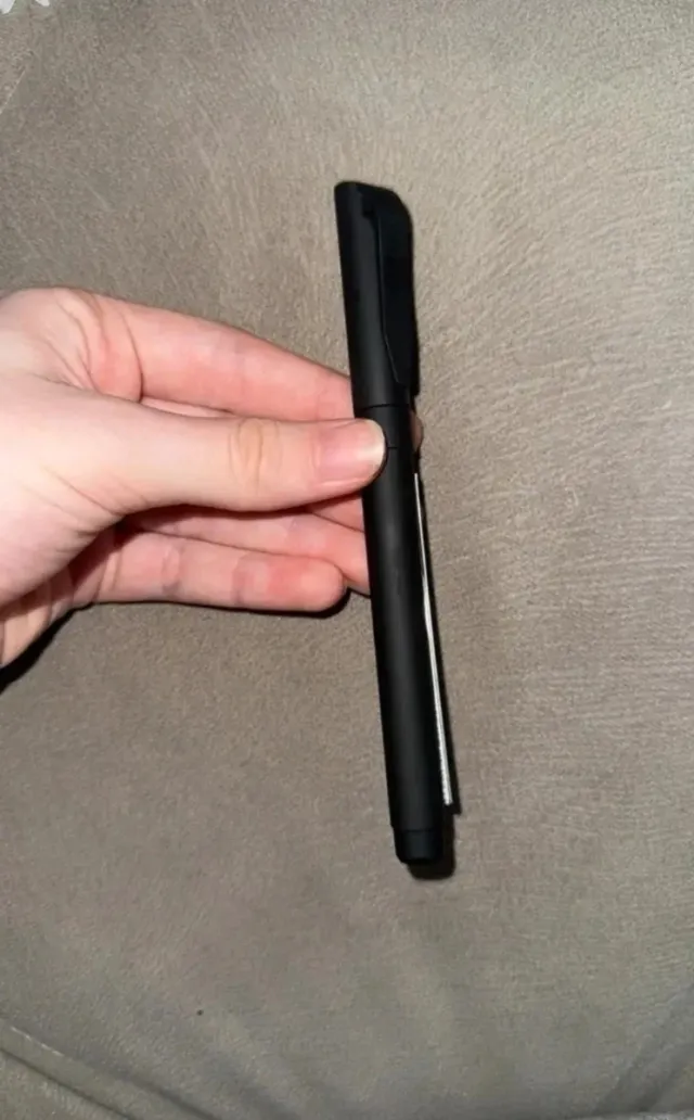 Caneta preta com tira de papel