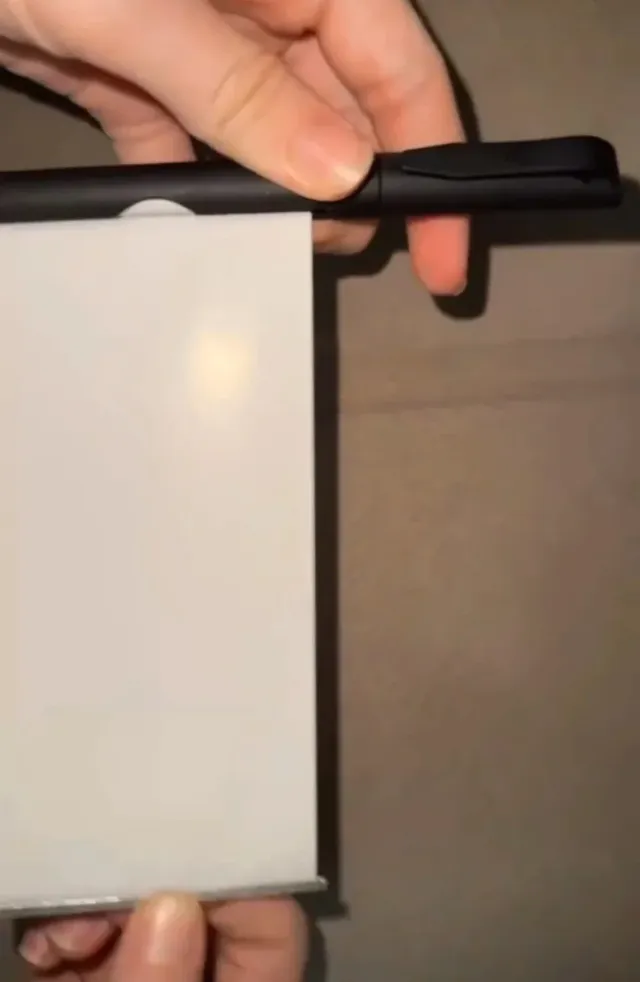 Caneta preta com tira de papel