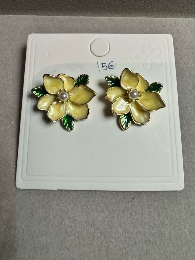Brincos de flor amarelos com detalhes verdes