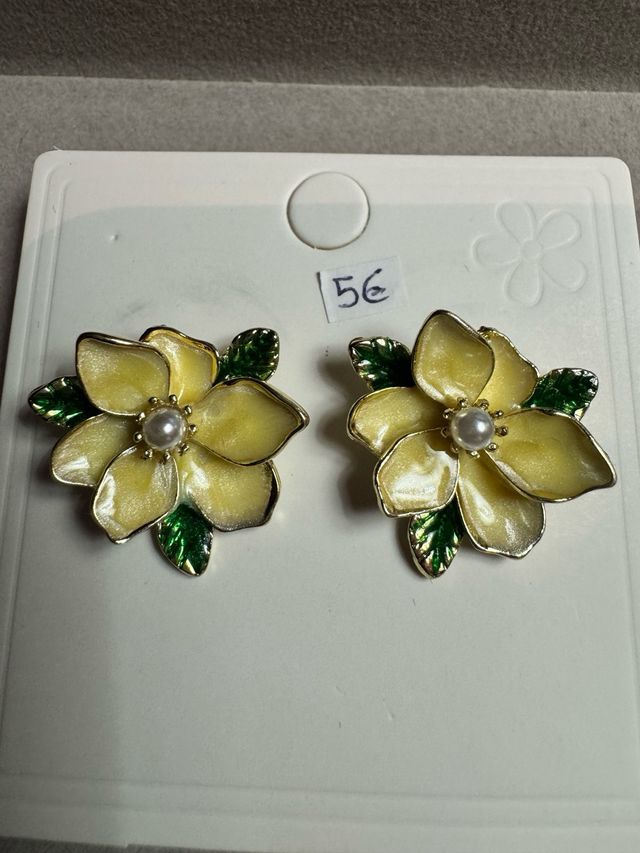 Brincos de flor amarelos com detalhes verdes