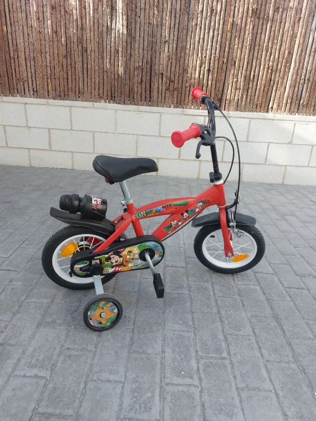 Bicicleta infantil roja con ruedines