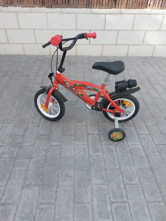 Bicicleta infantil roja con ruedines