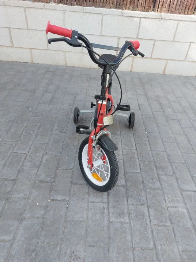 Bicicleta infantil roja con ruedines