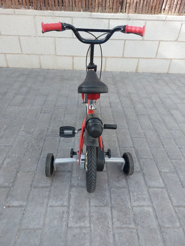 Bicicleta infantil roja con ruedines