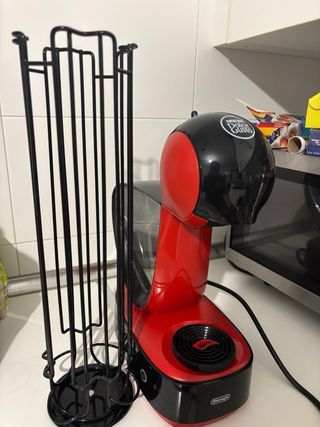 Cafetera Dolce Gusto más soporte de cápsulas.