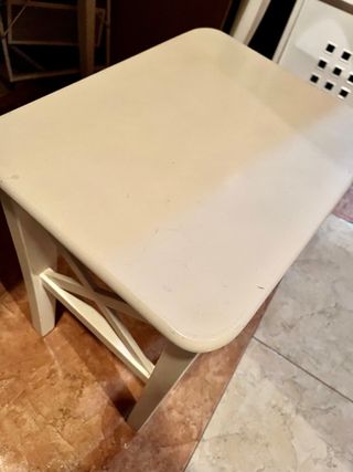 Tocador blanco con espejo y taburete.