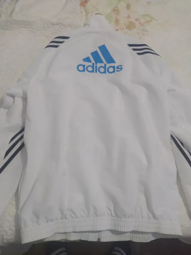 Sudadera Adidas Blanca y azul con rayas negras.