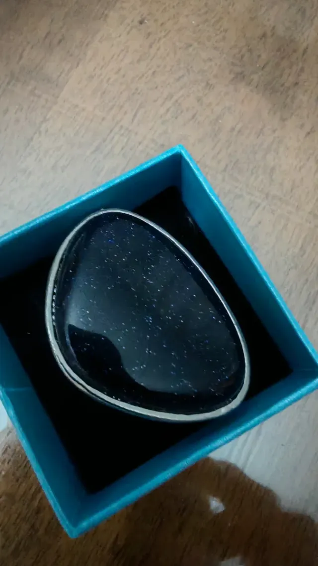 Anillo piedra negra con destellos brillantes.
