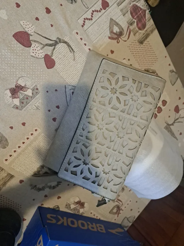 Pochette beige con decorazioni floreali traforati