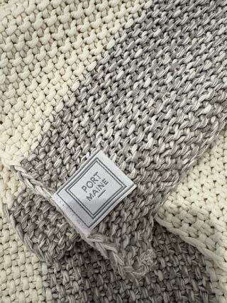 Manta y cojines decorativos grises y blancos