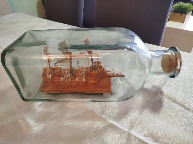 Botella de cristal con barco de madera