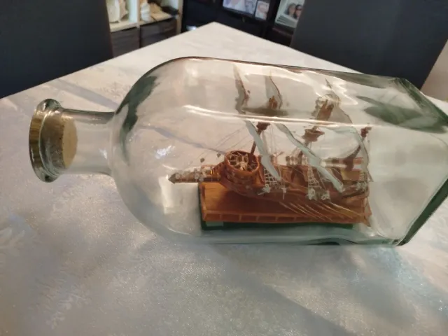 Botella de cristal con barco de madera