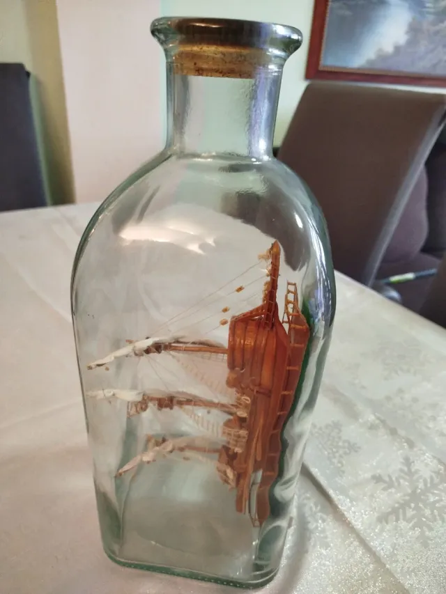 Botella de cristal con barco de madera