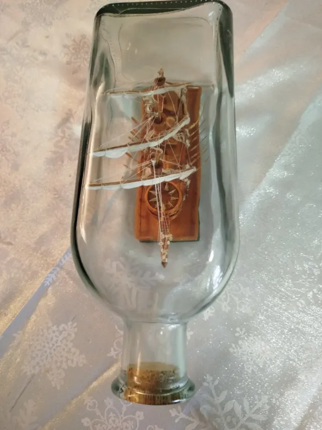 Botella de cristal con barco de madera