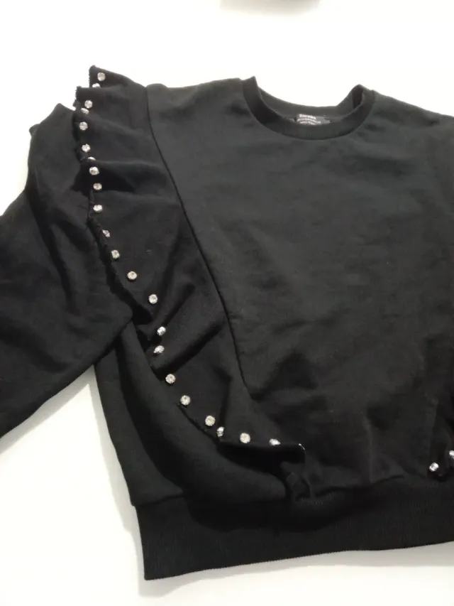 Sudadera negra con volantes y pedrería