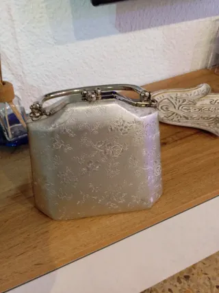Bolso de mano plateado con flores
