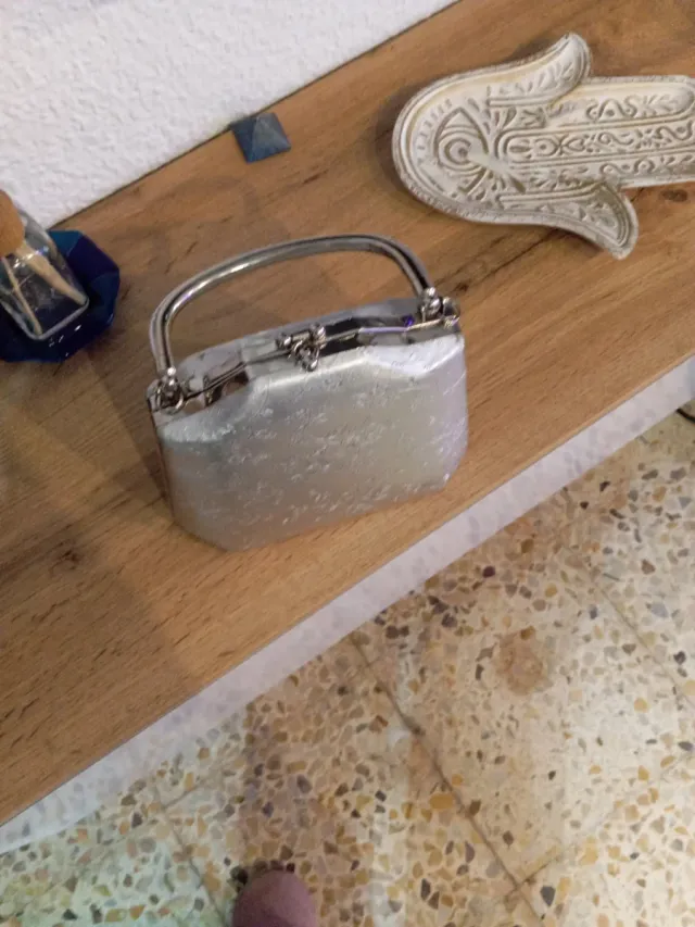 Bolso de mano plateado con flores