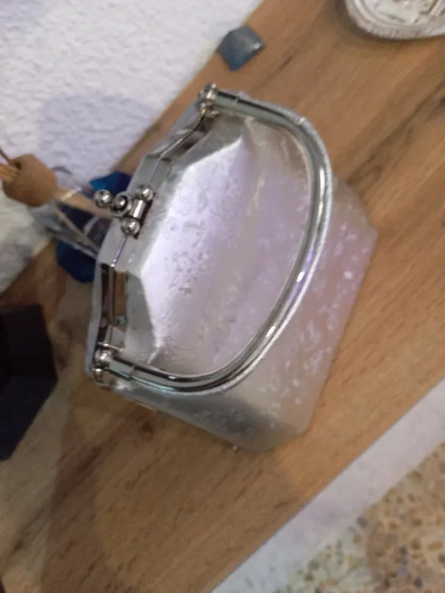 Bolso de mano plateado con flores