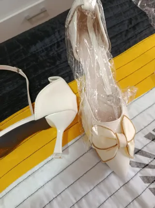 Zapatos de tacón blancos con lazo dorado