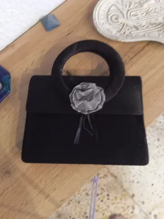 Bolso de mano negro con flor gris