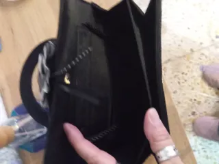 Bolso de mano negro con flor gris