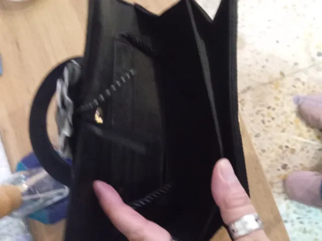 Bolso de mano negro con flor gris