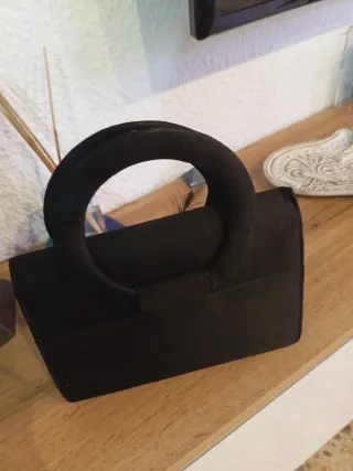 Bolso de mano negro con flor gris