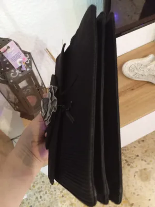 Bolso de mano negro con flor gris