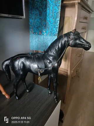 Caballo de cuero marrón y negro con silla